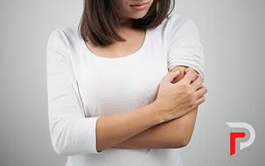 a woman scratches her arm from itchy bed bug bites