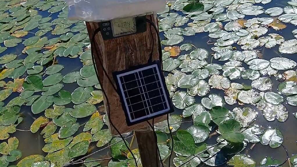 solar powered pump on edge of pond bank