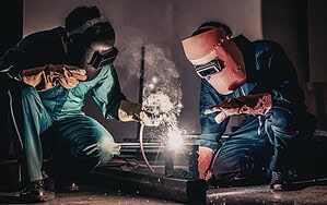 2 men welding industrial components
