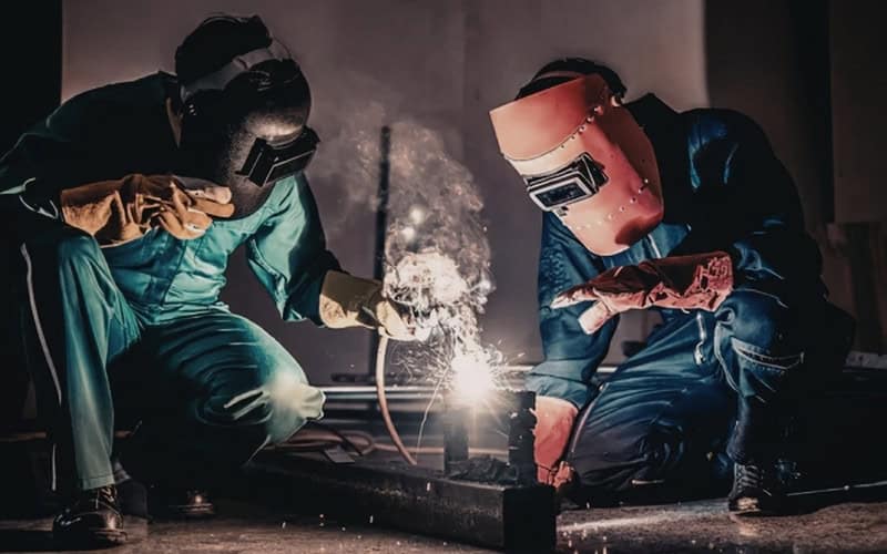 2 men welding industrial components